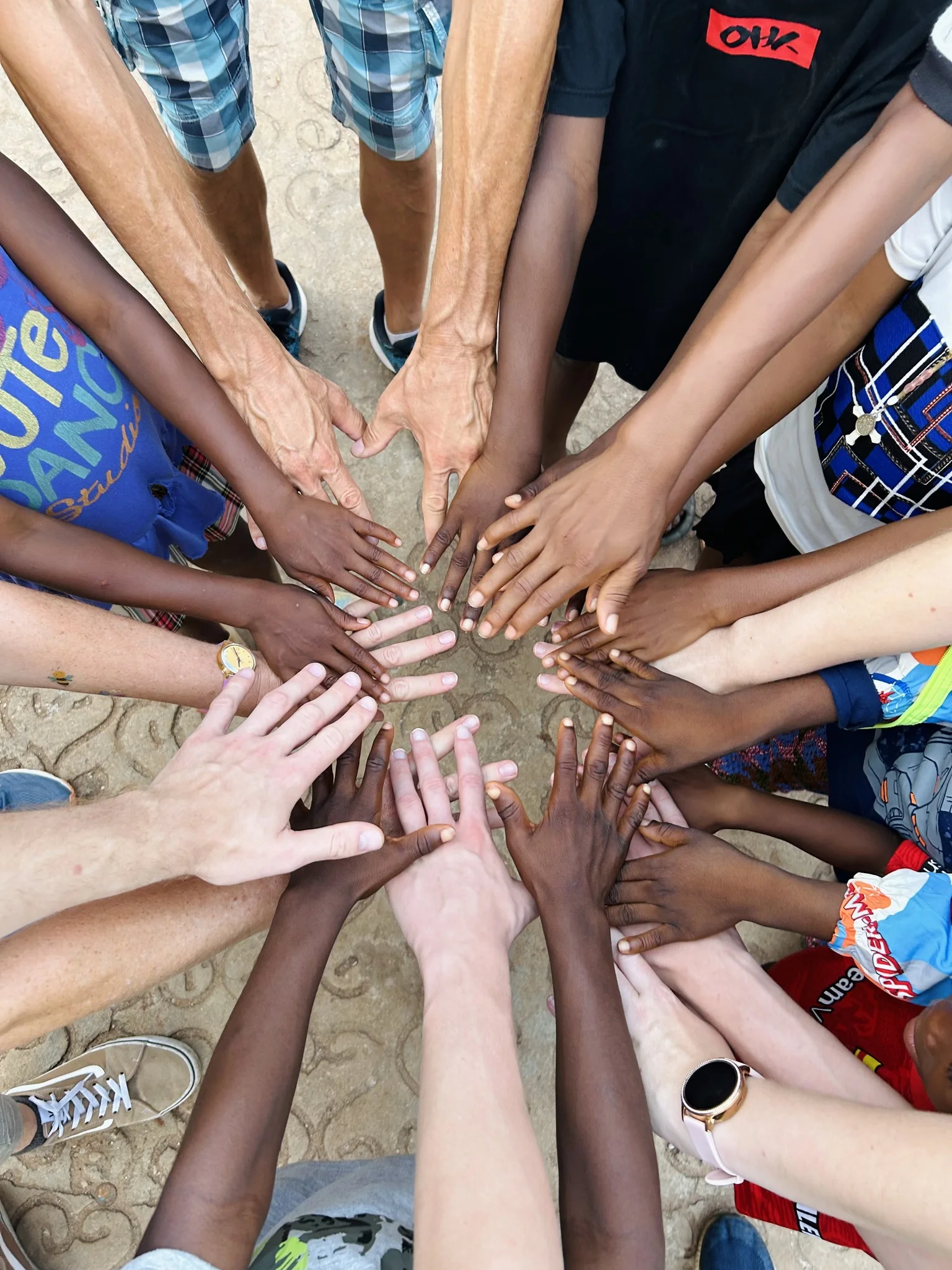many hands of various skin colors forming a circle